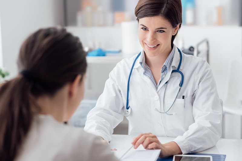 Médecin généraliste à son bureau avec une patiente