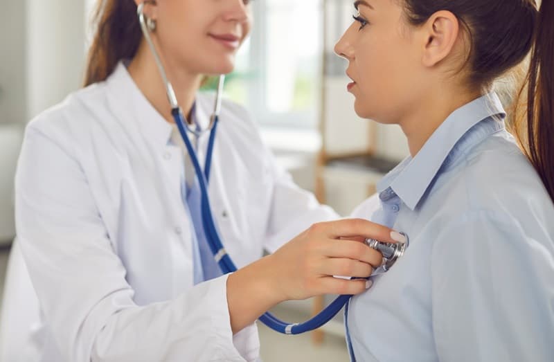 Médecin généraliste qui osculte une patiente