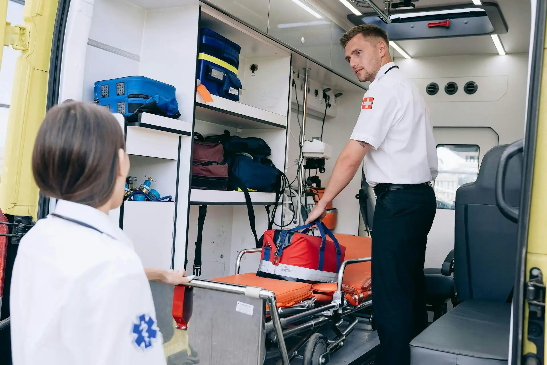 ambulanciers dans leur véhiculeavec un brancard et leur matériel 