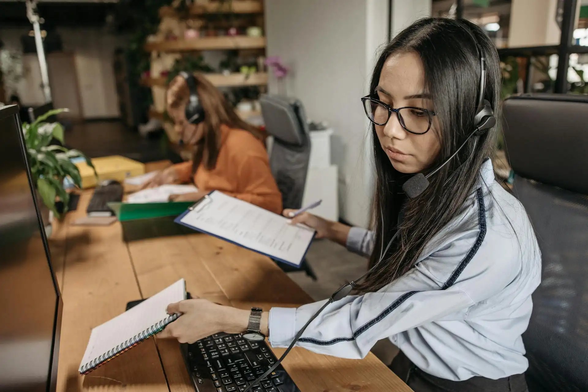 femme à son bureau avec des carnets à la main 