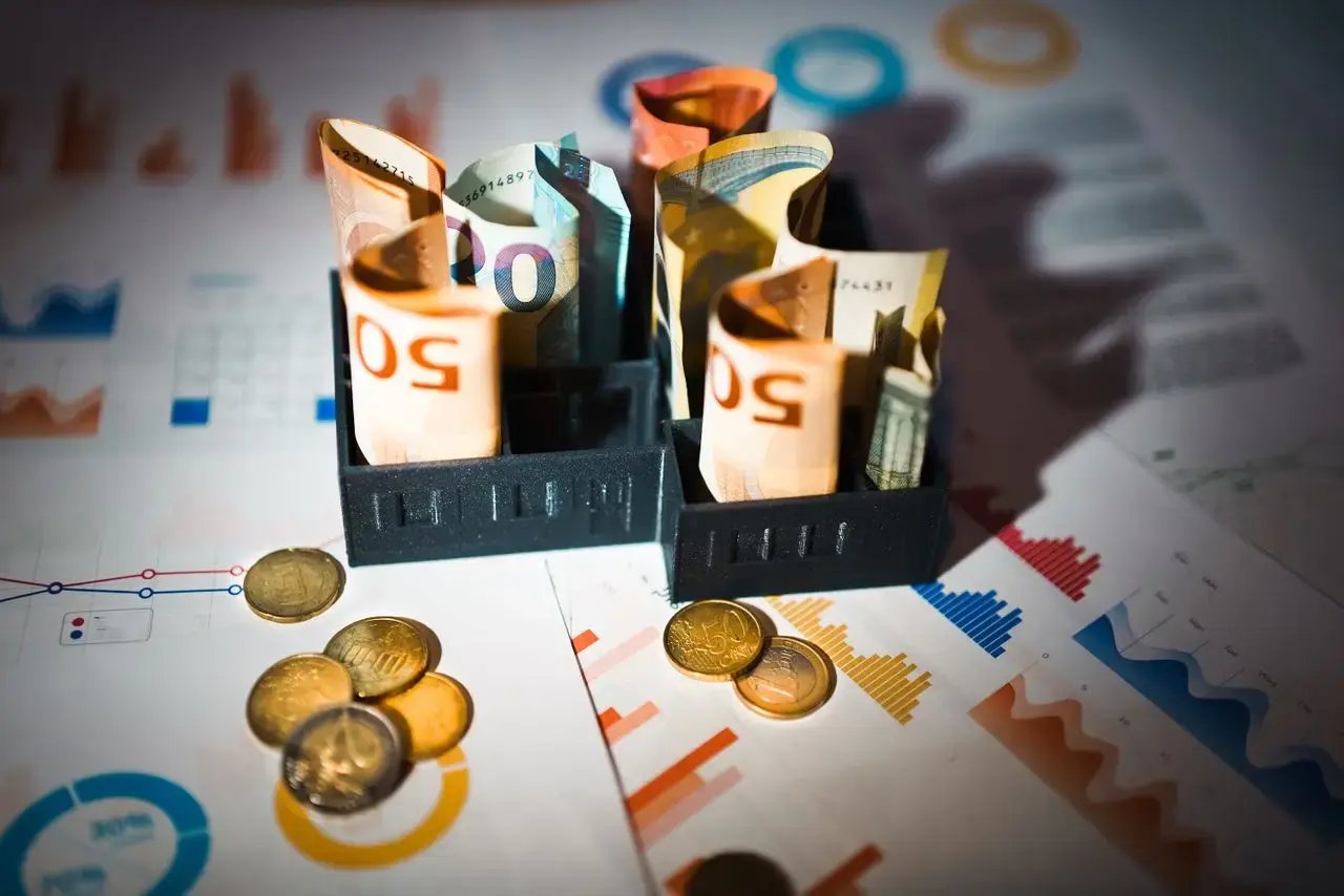 Des billets et des pièces posés sur des graphiques