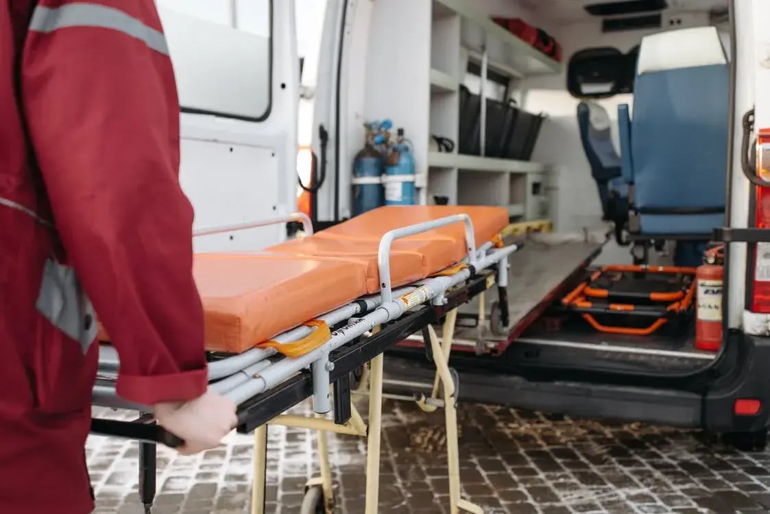 ambulancier qui rentre un brancard dans le véhicule de secours