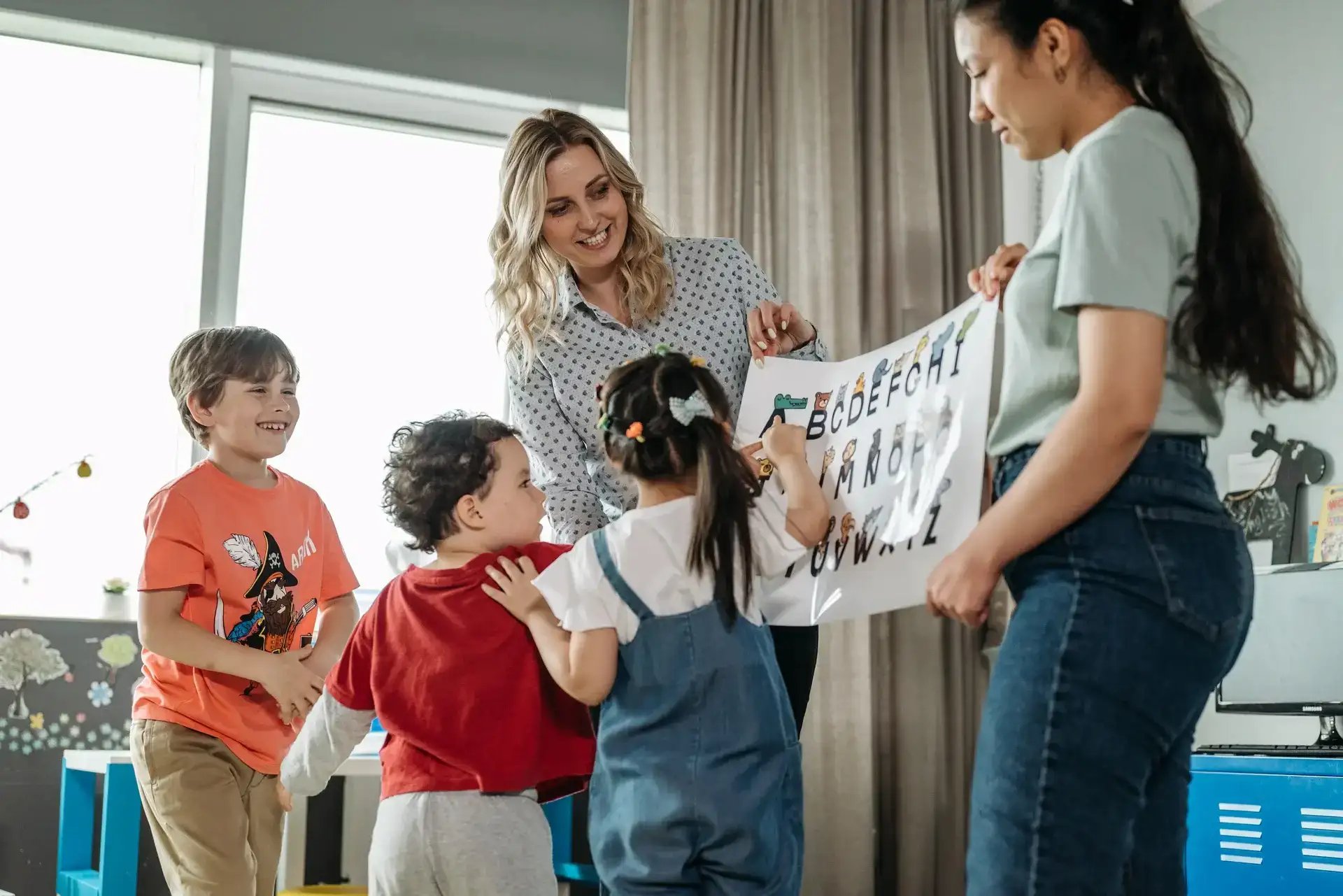 enfants apprenant l'alphabet à l'aide d'une affiche