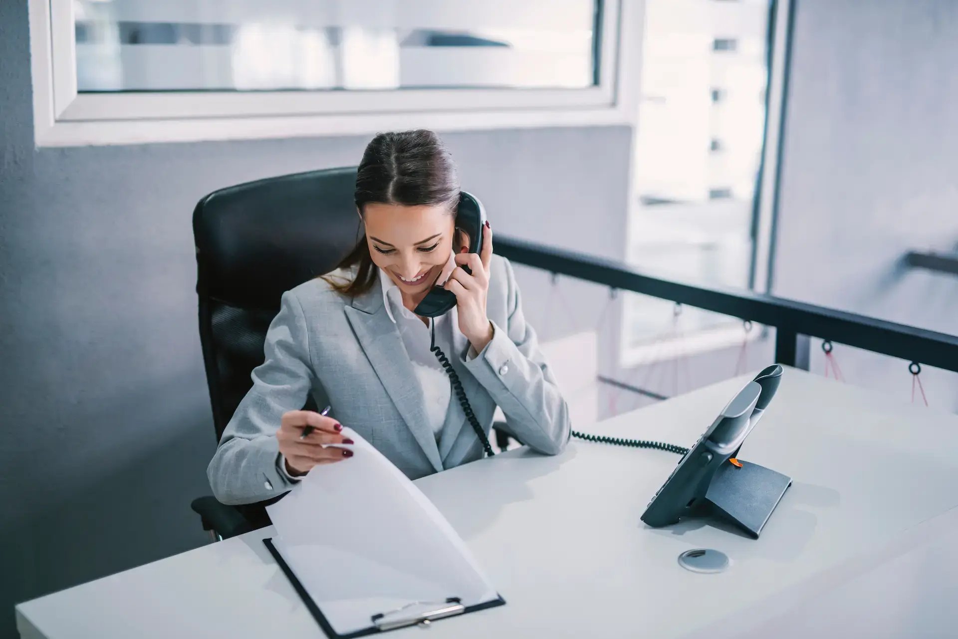 femme à son bureau au téléphone