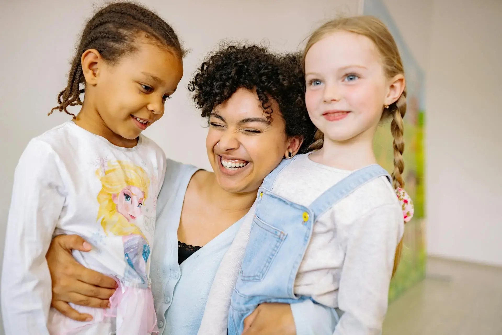 une femmes et deux enfants se faisant un calin en souriant
