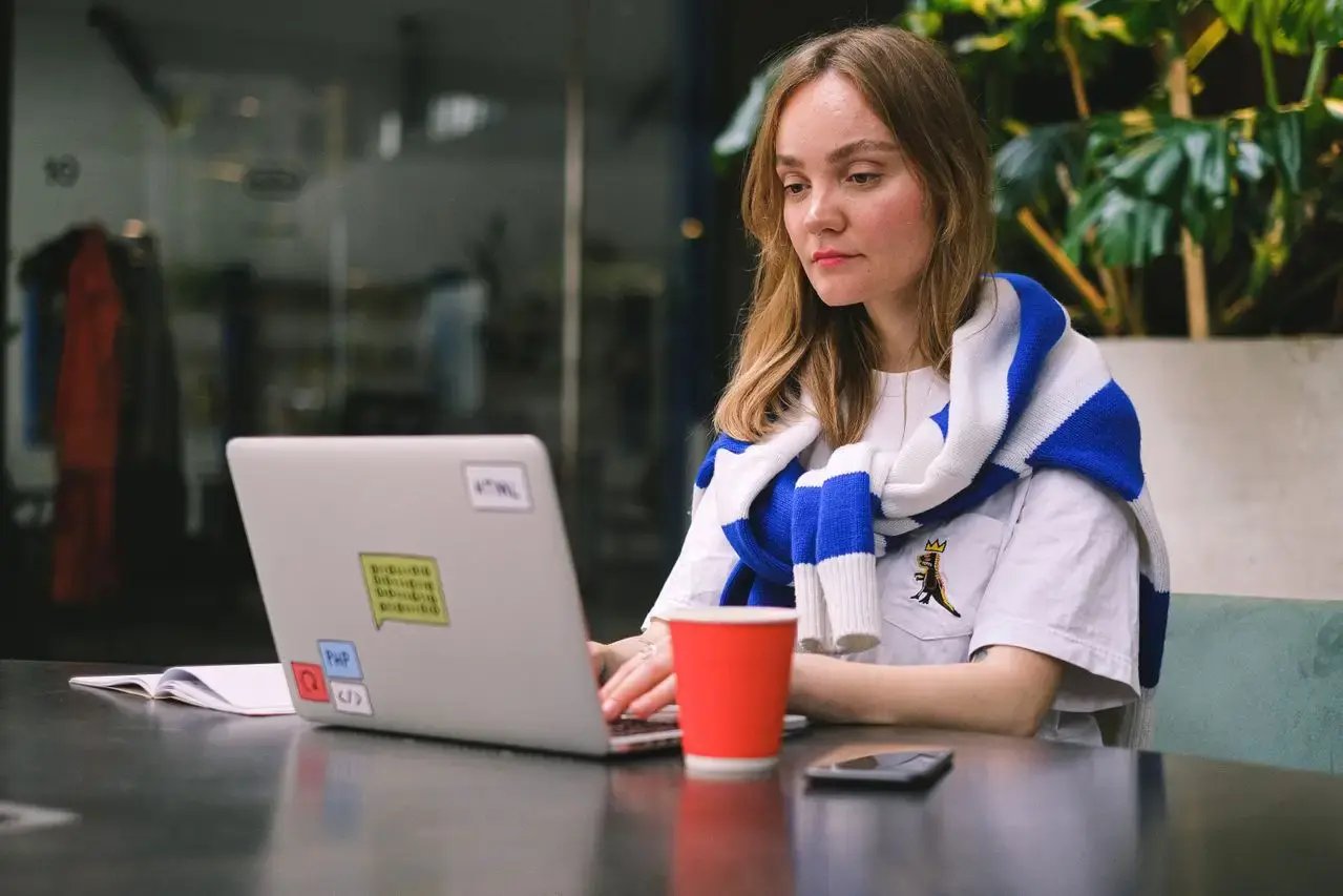 Une femme travaille dehors avec un café