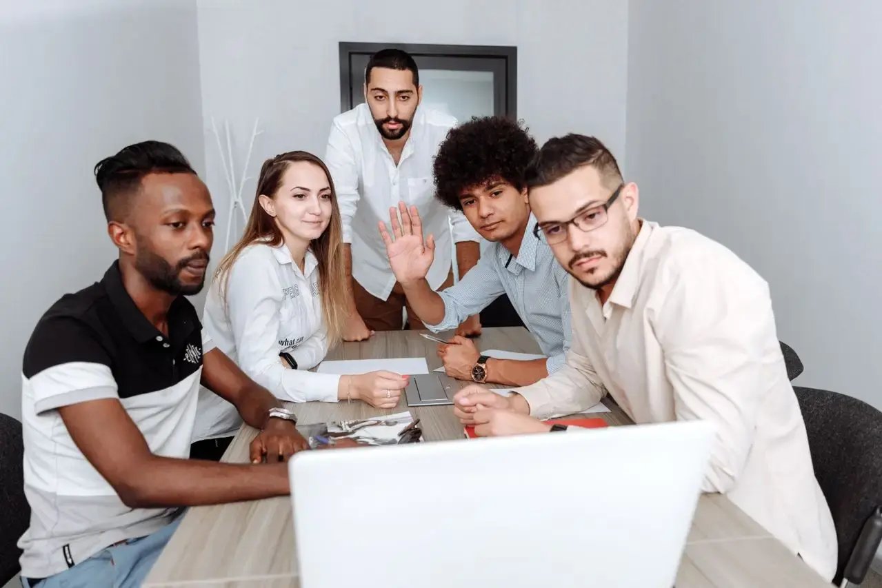 Un groupe de jeunes se présente devant un ordinateur 