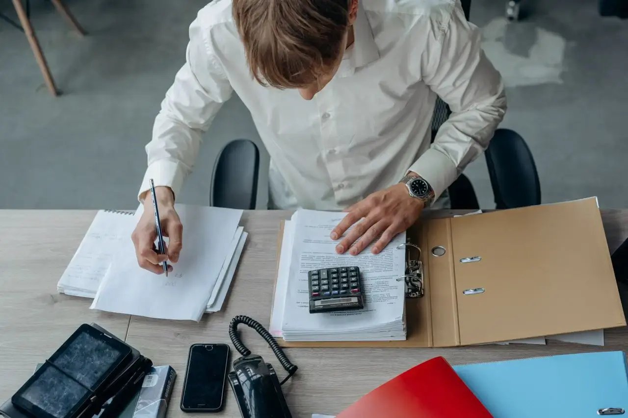 Un homme écrit à son bureau