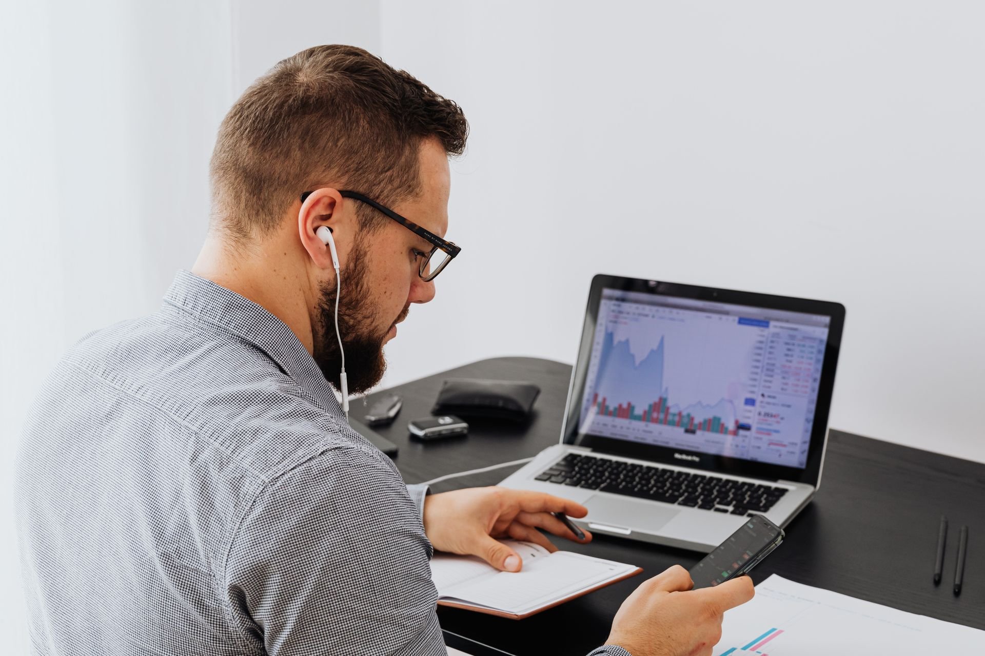 homme travaillant sur son téléphone et son ordinateur