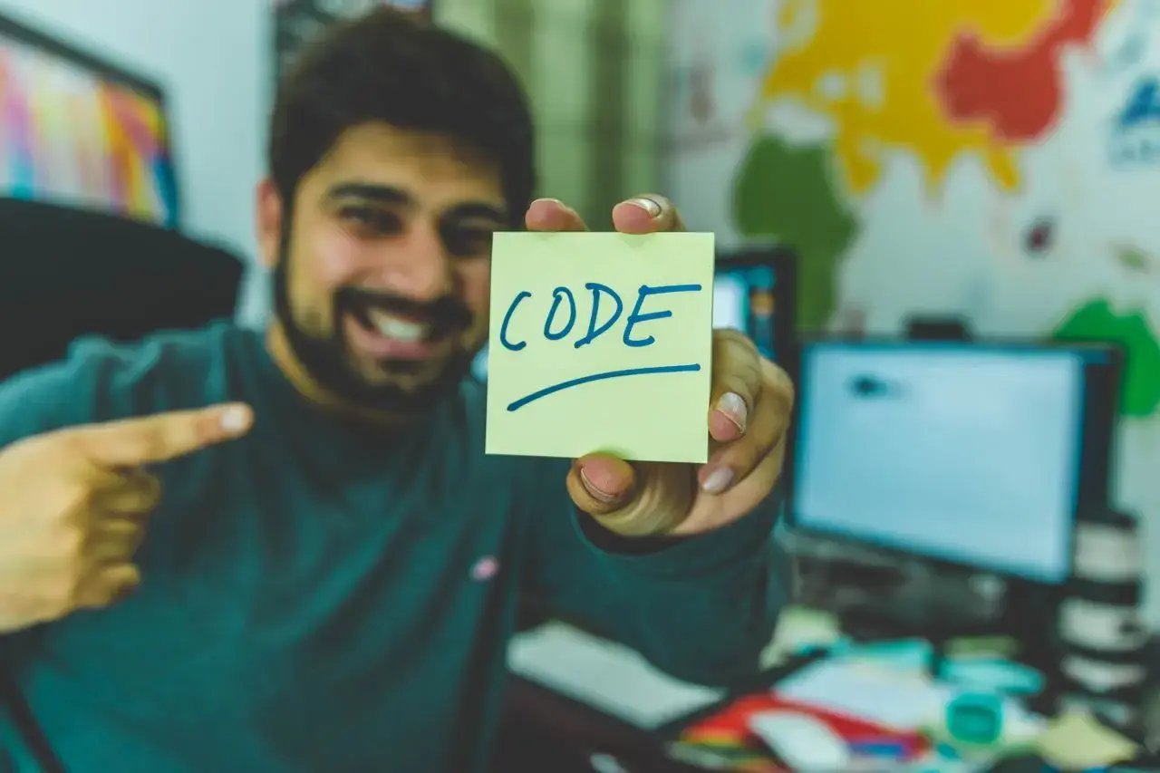 Un homme sourit en montrant le mot code