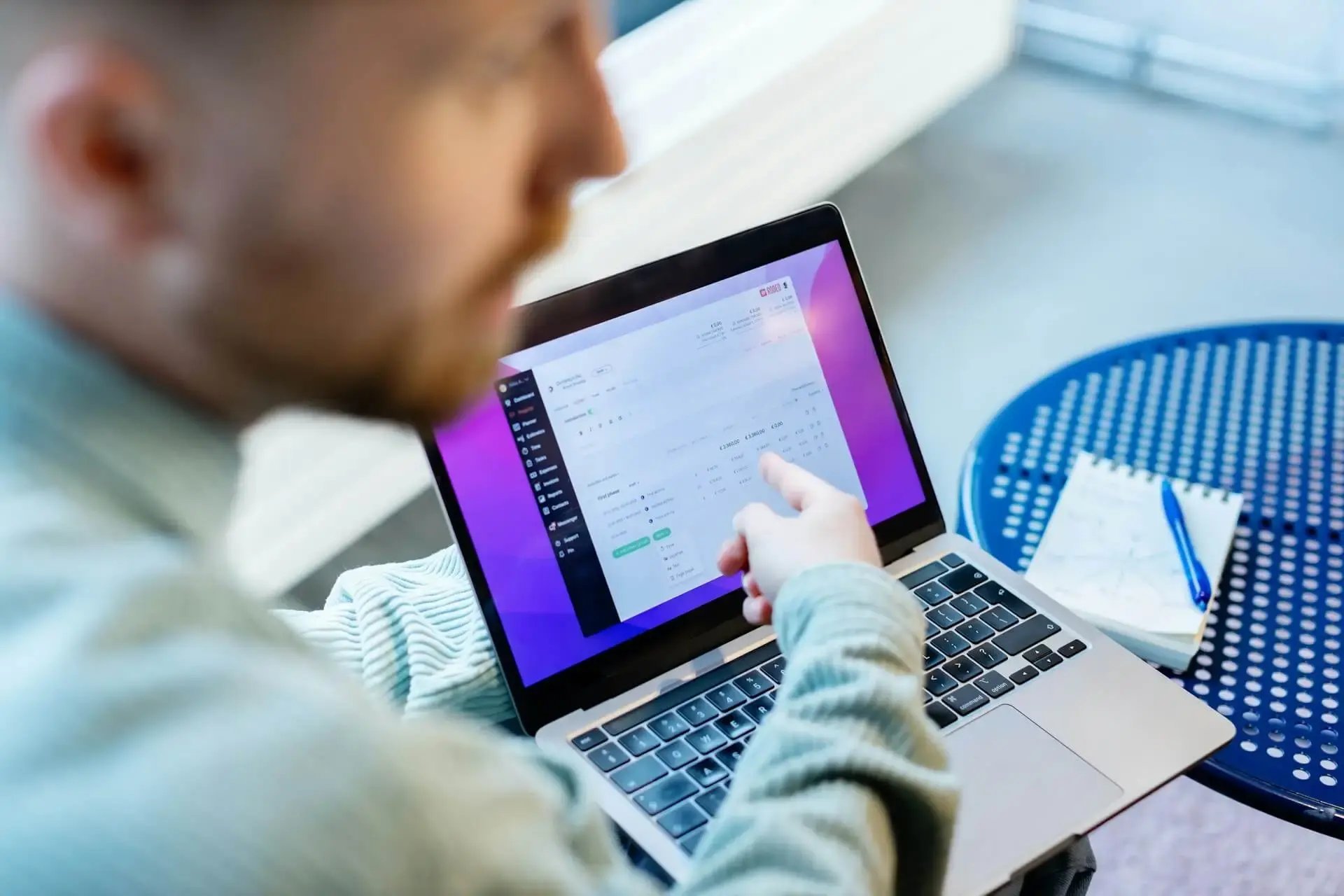 Une personne montrant un document sur un ordianateur portable