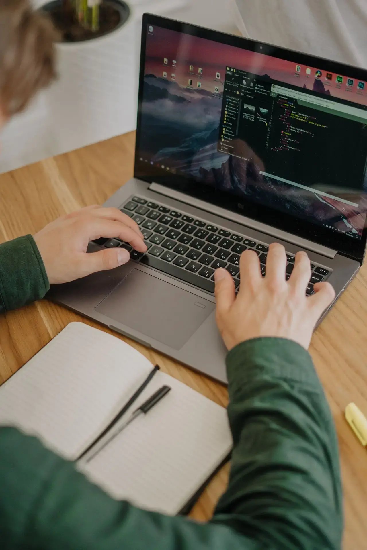 Un web developpeur travaille avec son cahier et son ordinateur