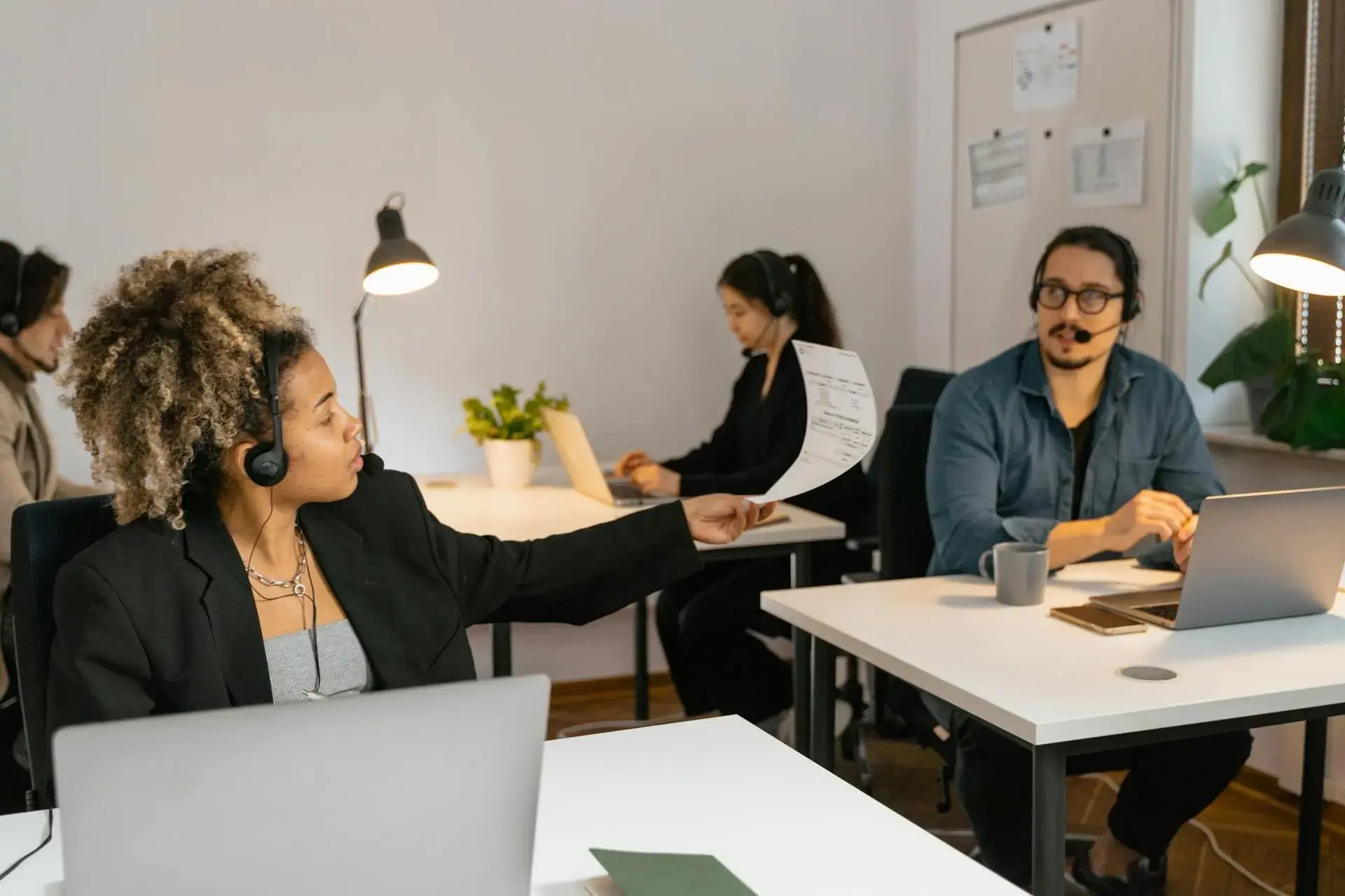 femme tendant un document à son collègue du bureau d'à côté
