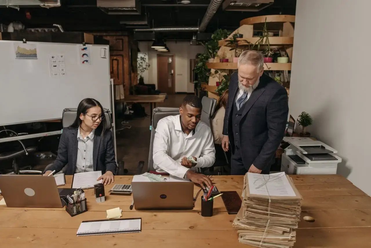 Trois personnes travaillent ensemble sur un bureau