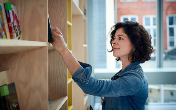 bibliothécaire qui cherche un livre dans une bibliothèque